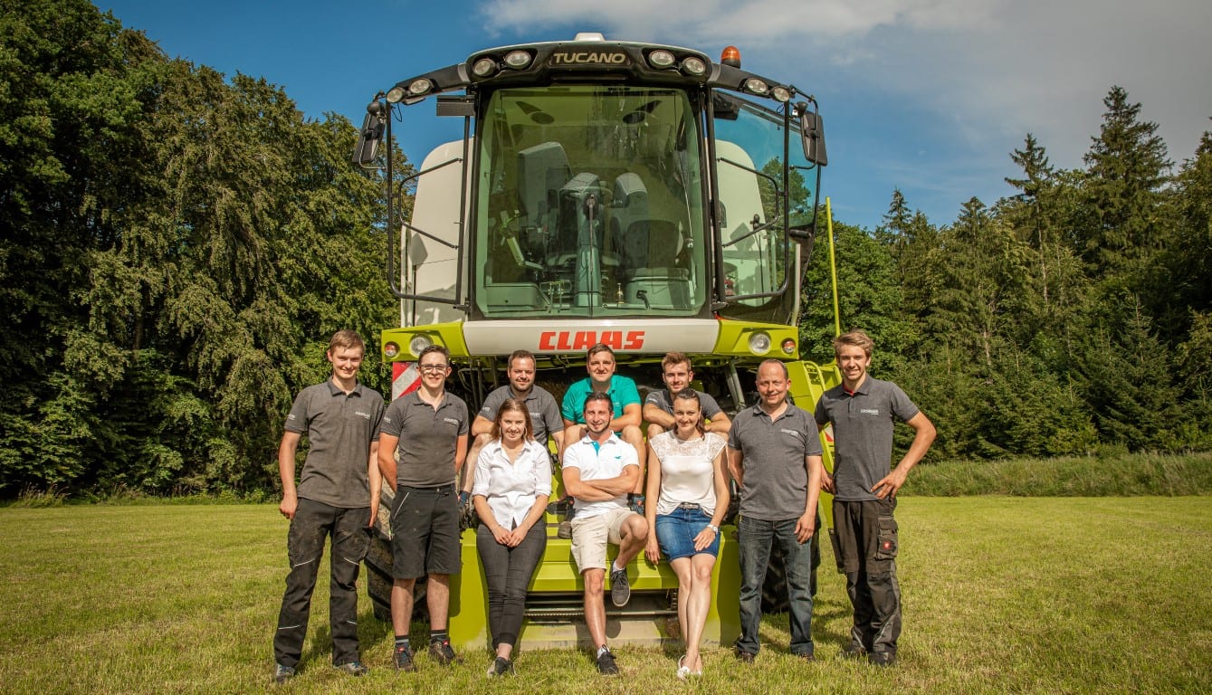 Team Pongruber Landtechnik vor einem CLAAS Mähdrescher